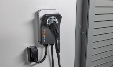 A wall-mounted Level 2 EV charger with a plug-in cord;
